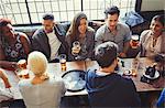 Overhead view of friends drinking beer and wine at table in bar