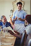 Waiter taking order from couple with menus at restaurant table