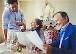 Waiter taking order from senior couple with menus at restaurant table