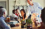 Waiter serving fireworks birthday cake to happy woman at restaurant table