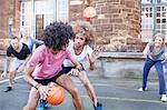 Friends playing basketball on urban basketball court