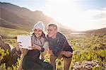Young couple taking selfie with digital tablet camera in sunny valley