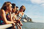 Four adult friends looking out from river waterfront, New York, USA