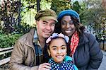 Family in park looking at camera smiling