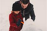 Father and daughter making snowman