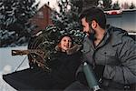 Father and daughter on back of pick up truck with their Christmas tree