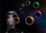 Young boy wearing virtual reality headset, holding planet in hand, digital composite