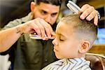 Barber shaving boy's hair