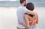 Couple hugging by river