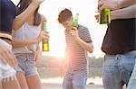 Group of friends drinking, enjoying beach party