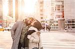 Young woman kissing boyfriend on street, New York, USA