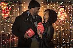 Romantic couple exchanging christmas gifts at night, New York, USA