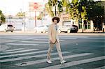 Teenage boy with red afro hair, wearing suit, on pedestrian crossing