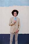 Portrait of teenage boy with red afro hair, wearing suit, outdoors