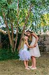 Two young girls dressed as fairies, holding hands, face to face