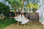 Two young girls, dressed as fairies, dancing outdoors