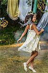 Young girl dressed as fairy, holding wand, playing outdoors