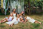 Portrait of mature woman with group of young girls, dressed as fairies, outdoors