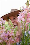 Close up portrait of young woman holding bunch of snapdragons (antirrhinum) from flower farm field