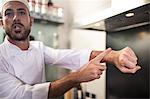 Chef signalling time by putting finger on wrist