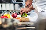 Chef chopping green pepper on chopping board