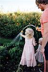 Father with daughters watering vegetables