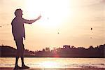 Man using cell phone to photograph sunset