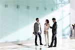 Business associates chatting in office corridor