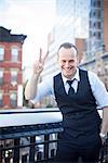 Businessman making a peace sign gesture, smiling cheerfully, portrait