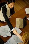 Businesswomen shaking hands during meeting