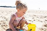 Little girl playing in sand on beach