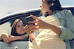 Woman leaning out of window from driver seat and talking to friend