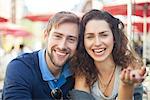 Young couple laughing together outdoors, portrait