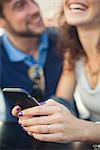 Woman using smartphone, laughing with boyfriend
