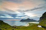 Pink clouds of the midnight sun reflected in the cold sea, Flakstad, Moskenesoya, Nordland county, Lofoten Islands, Norway, Scandinavia, Europe