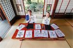 Caucasian couple practicing calligraphy at traditional Japanese house