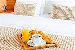 tray with healthy breakfast in bed in the hotel room