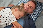 Father And Daughter Lying On Floor Asleep Together