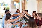 Friends making a toast at a dinner party on a patio, Ibiza