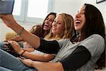 Teenage girl taking selfie with friends using her smartphone