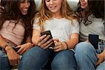 Teenage girl showing her friends   something on smartphone