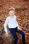 cheerful laughing little boy enjoying autumn golden leaves in the park