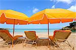 two umbrellas and three sunbeds at beautiful empty caribbean beach at anguilla island