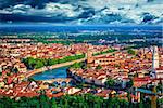 Panorama Italy town Verona and river Adige with dramatic sky urban landscape green tree bridge high tower.