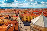 Panoramic view Baptistery of San Giovannito in Florence and tile roofs old town houses. Green hills blue sky with clouds summer landscape on background. Firenze, Italy.