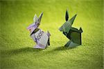 origami hare from banknotes a green background