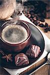 Cup fragrant hot coffee with bean chocolate sweet and loaf in vintage rustic style cinnamon steam smoke on wooden board for bracing morning breakfast