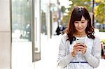 Fashionable Japanese woman with smartphone in luxury Tokyo area, Tokyo, Japan