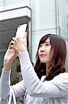 Fashionable Japanese woman with smartphone in luxury Tokyo area, Tokyo, Japan