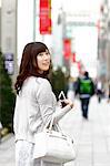 Fashionable Japanese woman with smartphone in luxury Tokyo area, Tokyo, Japan